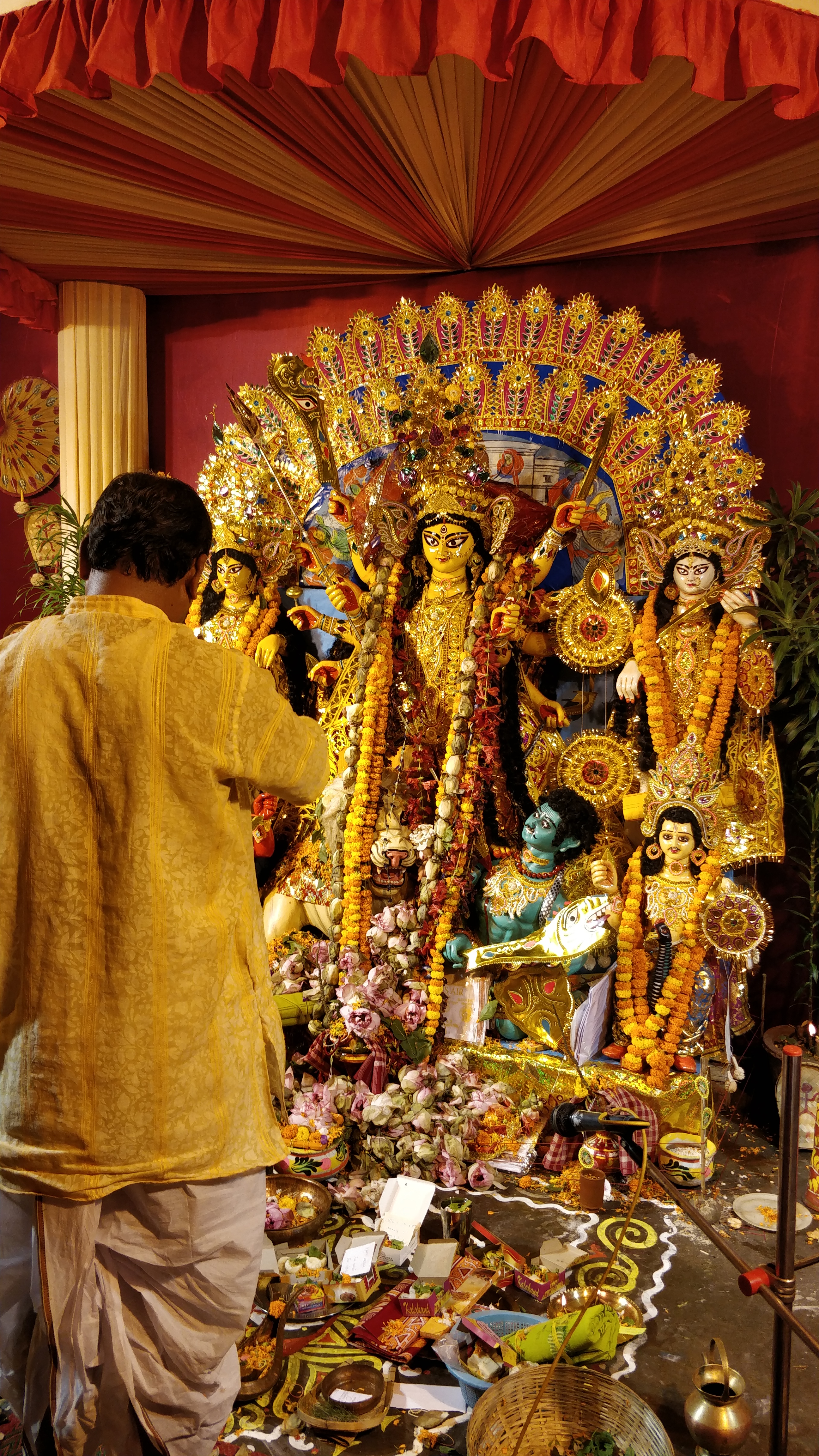 Communities conduct their own smaller pujos. Here, lotus flowers and offerings are placed at Durga's feet